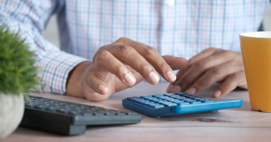 A calculator, fund statement, and notebook illustrating mutual fund fees and investing costs
