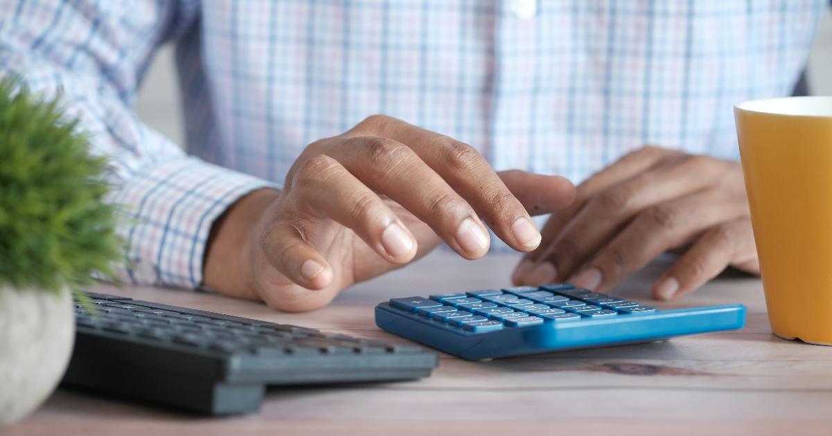 A calculator, fund statement, and notebook illustrating mutual fund fees and investing costs