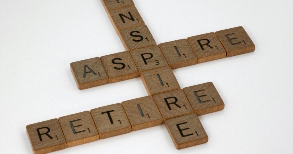 A retirement planning worksheet beside coins, a calculator, and labeled savings envelopes for cash and investments