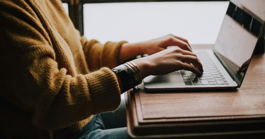 A person reviewing a monthly expense tracker on a laptop, illustrating a simple expense tracking method for better money clarity