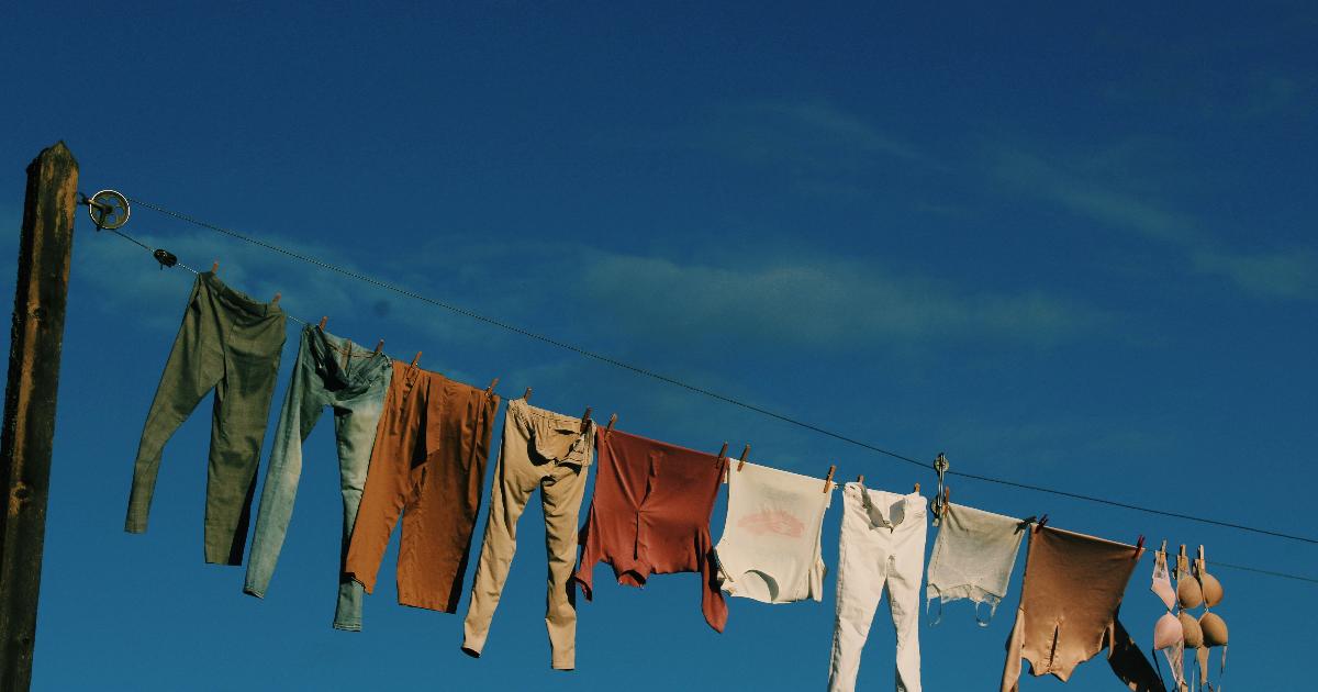 A clothesline with freshly washed shirts drying outdoors, illustrating a clothesline habit that can lower utility bills.
