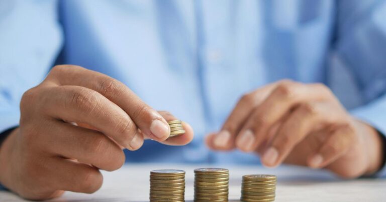 A person comparing savings account details on a laptop, checking an 8% savings rate and account rules