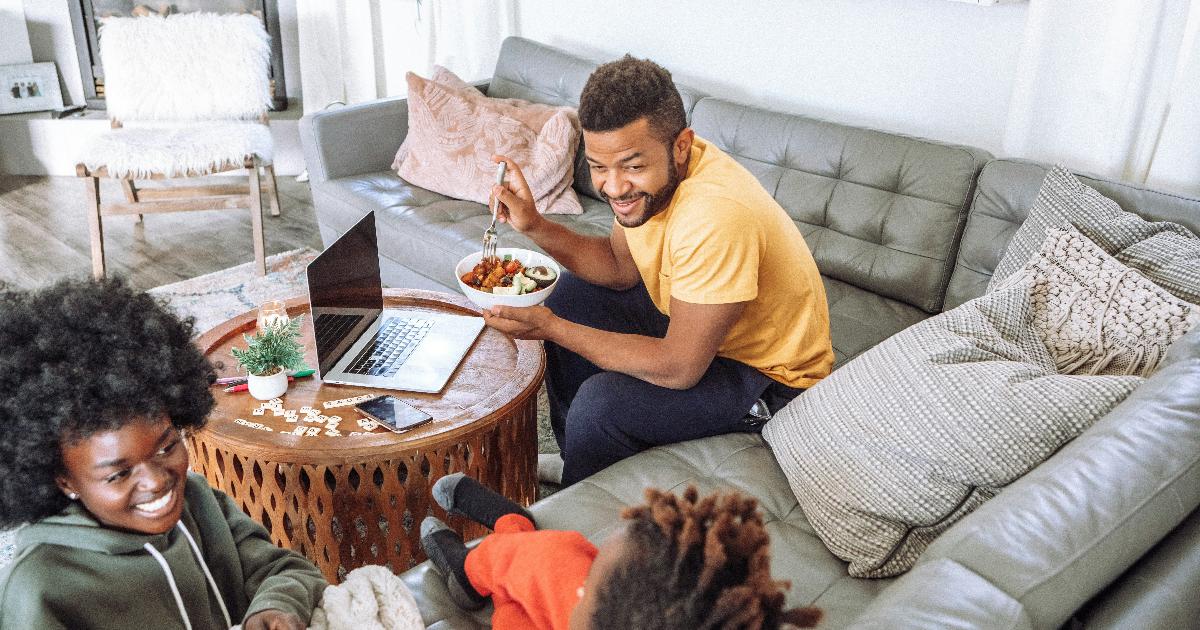 A family reviewing household bills and a savings plan at the kitchen table to build better family budgeting habits