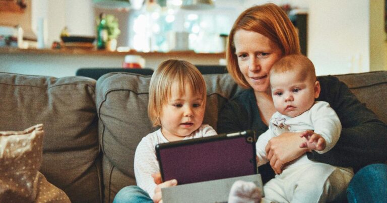 A family reviewing a budgeting app on a tablet, choosing a family budgeting app that fits their routine and money habits