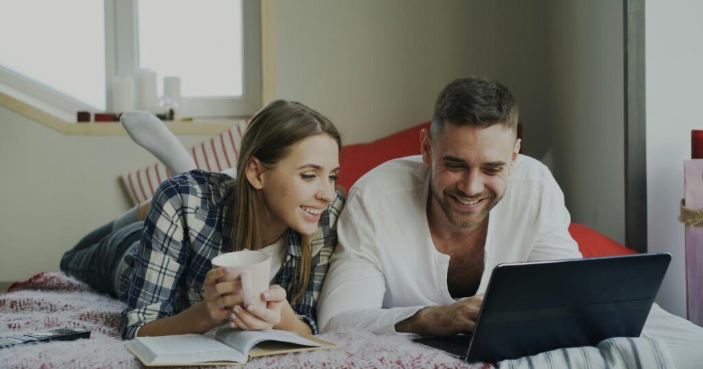 A couple reviewing a budgeting app on a tablet to track shared spending and bills together