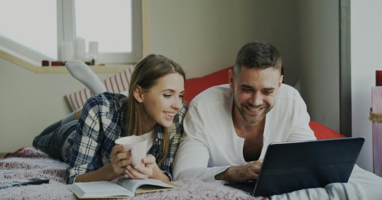 A couple reviewing a budgeting app on a tablet to track shared spending and bills together